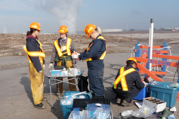 Professor Lesley Warren (standing, at right) and her colleagues are mining the genomes of microbes that thrive in wastewater generated by the resource extraction industry. Insights into how these organisms derive energy from metals and sulphur compounds could lead to new strategies for preventing pollution and optimizing mine reclamation. (Photo courtesy Lesley Warren)